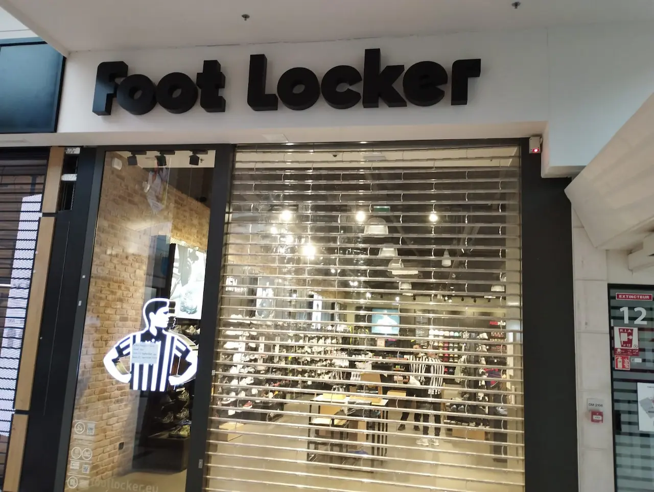 Devanture intérieure d'une boutique de sport à Mondeville nettoyée après chantier, vitrine et rideau métallique